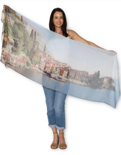Woman holding a large scarf with a scenic print on a white background