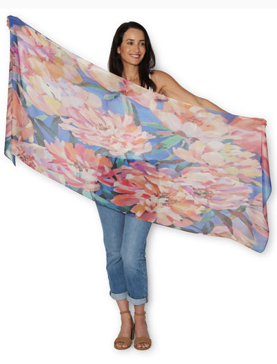 Woman holding a large floral scarf on a white background